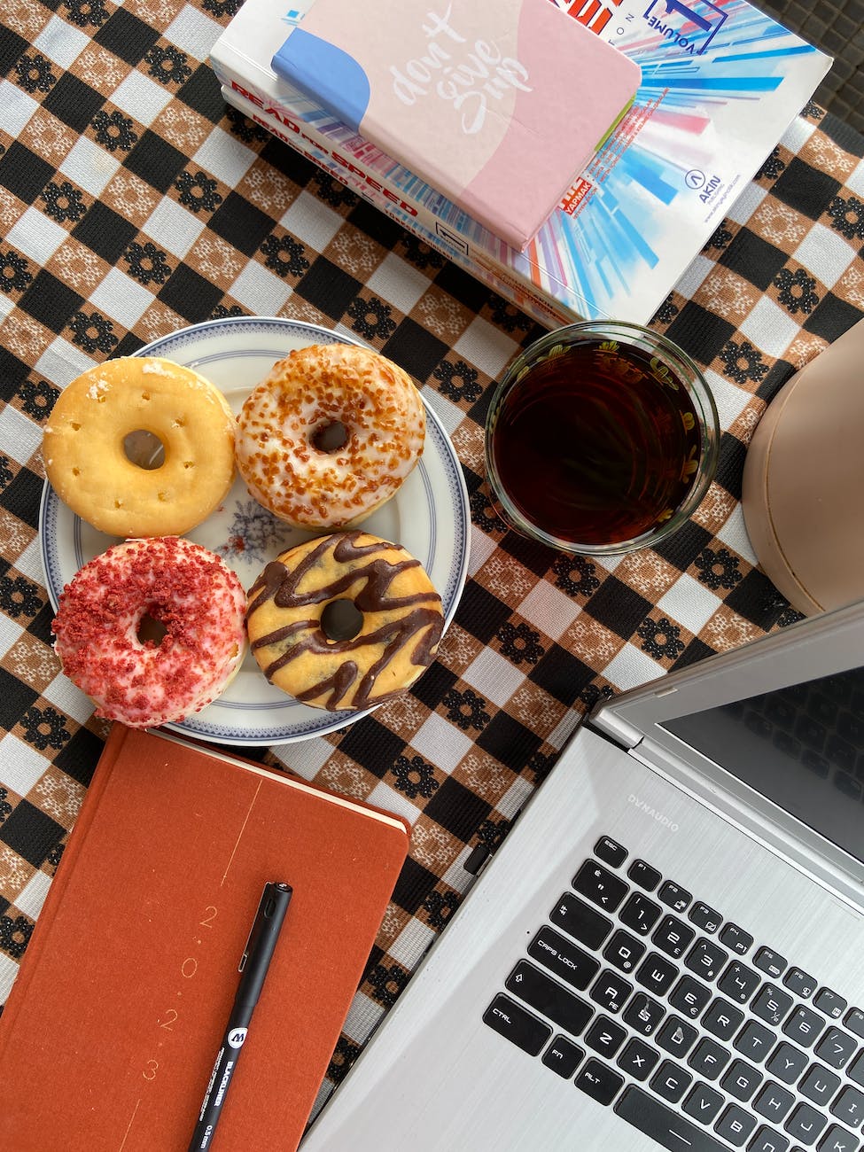 donuts and a glass of drink next to a laptop